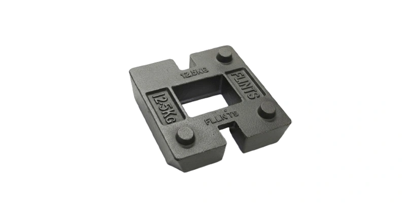 A black cast iron block labeled with the letter h used as a counterweight in various applications